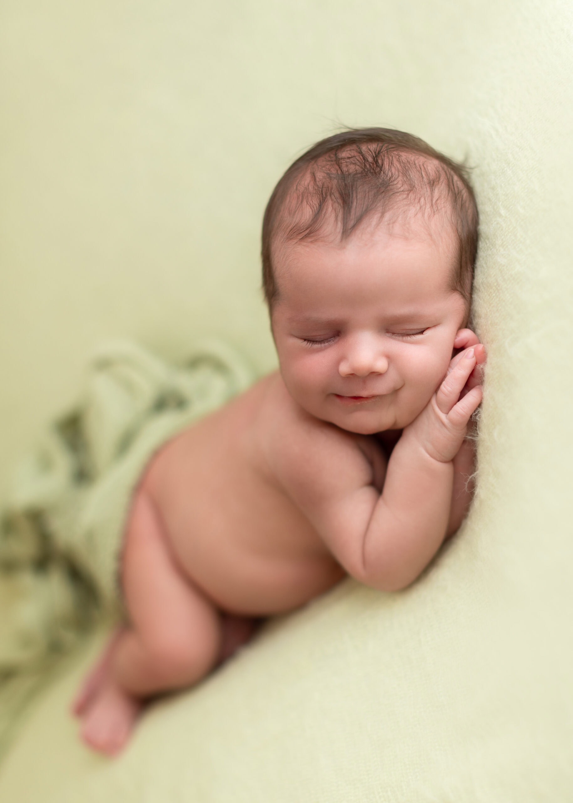 Newborn baby girl sleep in a soft blanket for a newborn photoshoot with timeless feeling